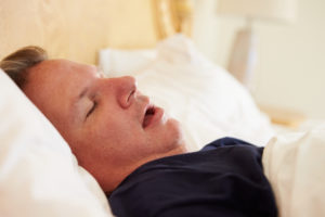 man suffering from symptoms of sleep apnea