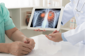 doctor explaining results of lung check up from x ray scan chest on digital tablet screen to patient.