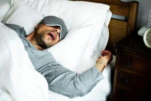 A man sleeping on a bed snoring